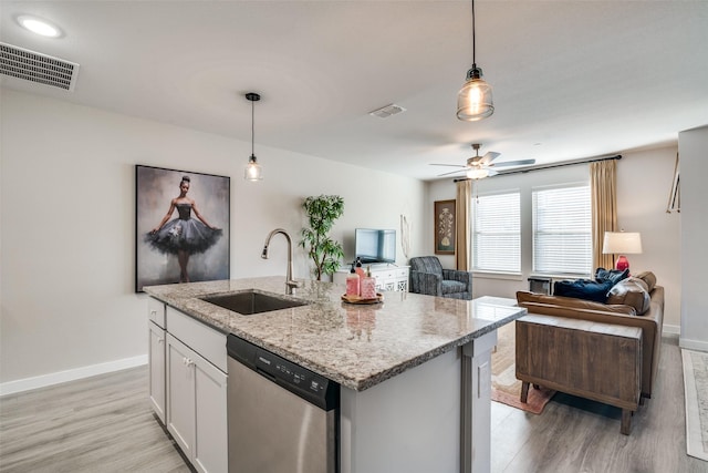 kitchen with sink, white cabinetry, hanging light fixtures, dishwasher, and an island with sink