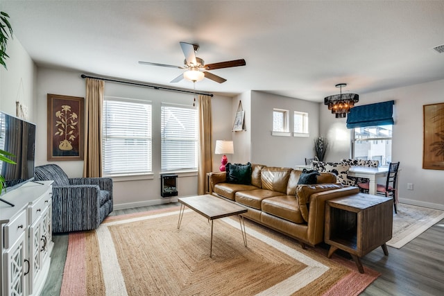 living room with wood-type flooring and ceiling fan with notable chandelier