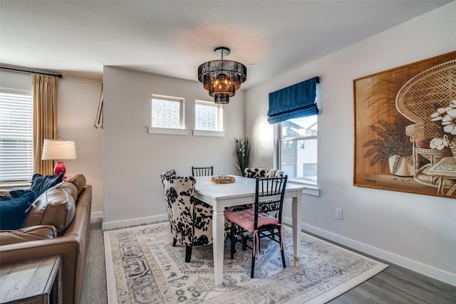 dining space featuring hardwood / wood-style floors and a notable chandelier