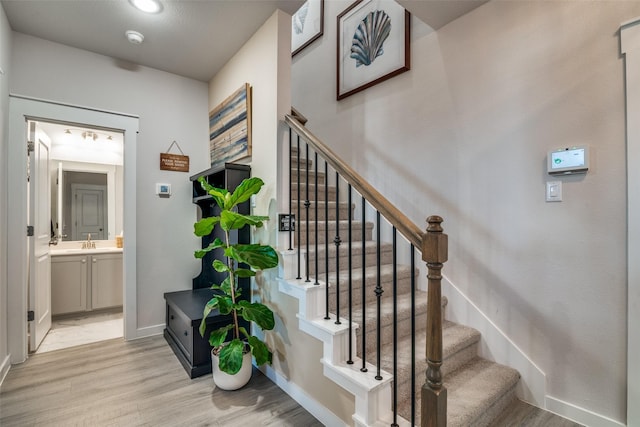 stairway with hardwood / wood-style flooring and sink