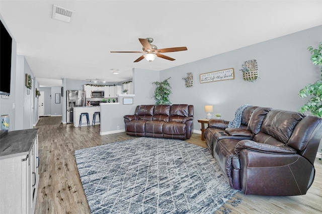 living room featuring ceiling fan and wood-type flooring