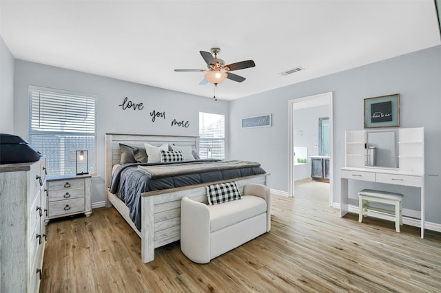 bedroom with ceiling fan, light wood-type flooring, and connected bathroom