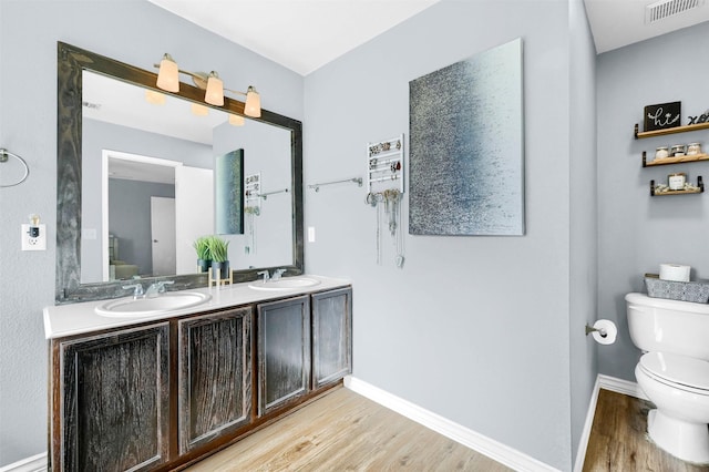 bathroom with hardwood / wood-style floors, vanity, and toilet