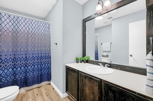 bathroom with vanity, toilet, and wood-type flooring