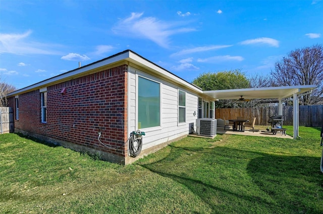 view of side of home featuring ceiling fan, central air condition unit, a patio, and a yard