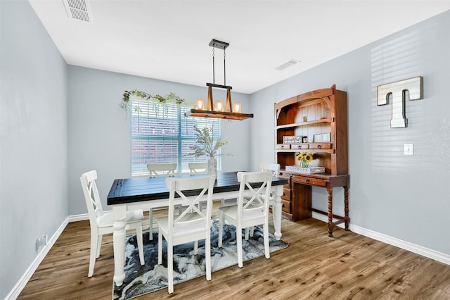 dining space with a chandelier and wood-type flooring