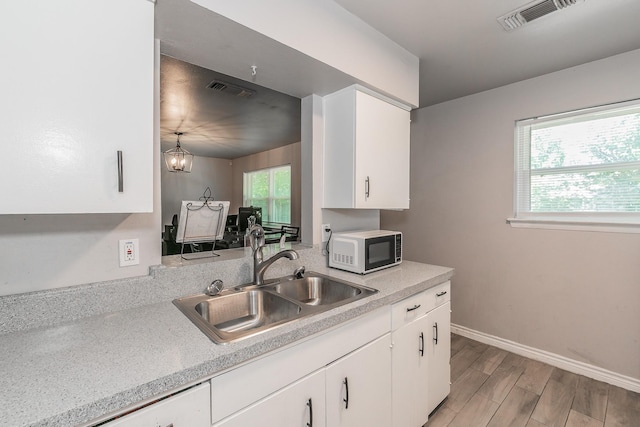 kitchen featuring sink, white cabinets, white appliances, and an inviting chandelier