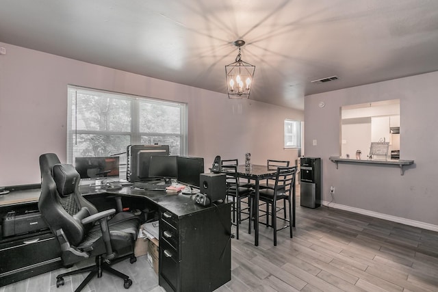 home office featuring hardwood / wood-style flooring and an inviting chandelier