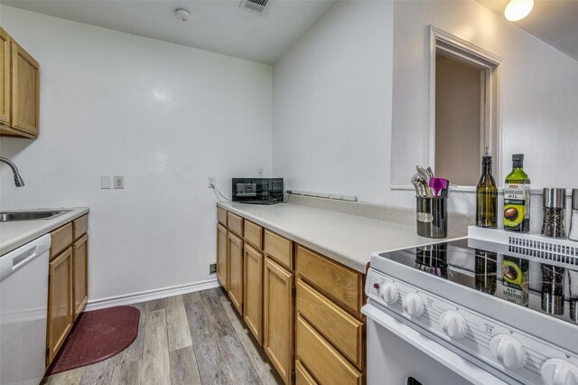 kitchen featuring white appliances, light hardwood / wood-style floors, and sink