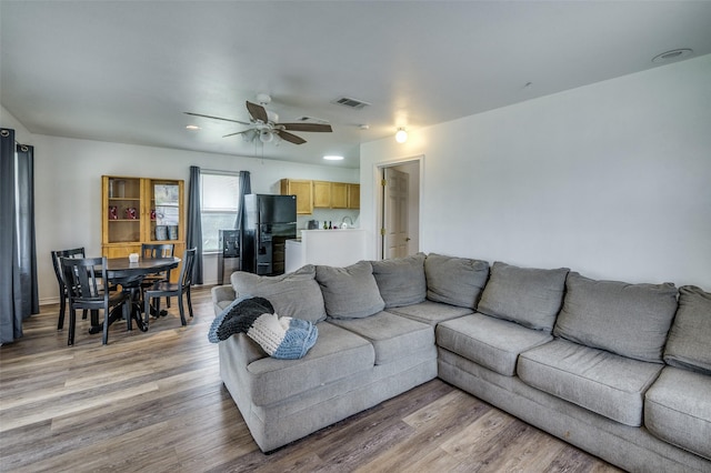 living room featuring ceiling fan and light hardwood / wood-style floors