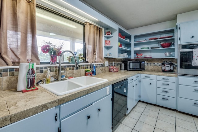 kitchen featuring light tile patterned flooring, sink, decorative backsplash, and black appliances