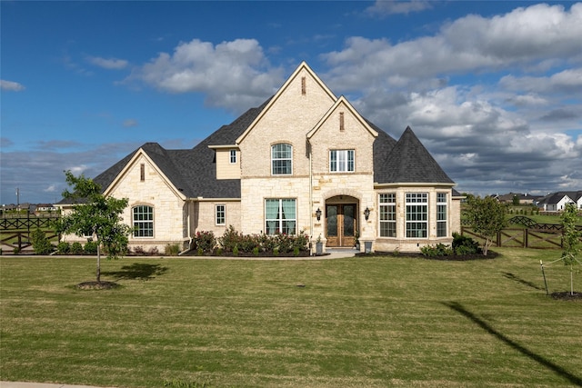 french country home featuring a front lawn and french doors