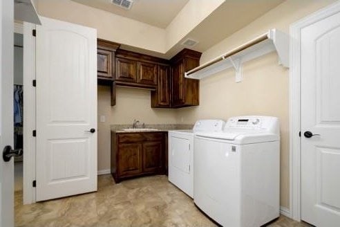 washroom featuring cabinets, separate washer and dryer, and sink