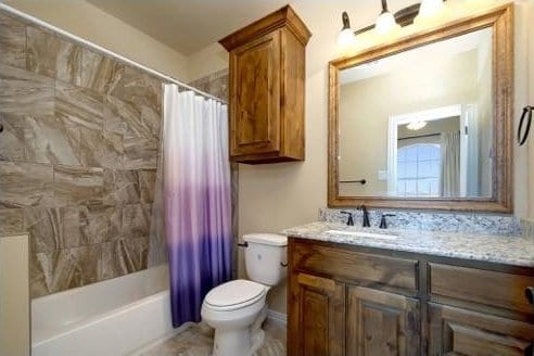 full bathroom with vanity, shower / bath combo, and toilet