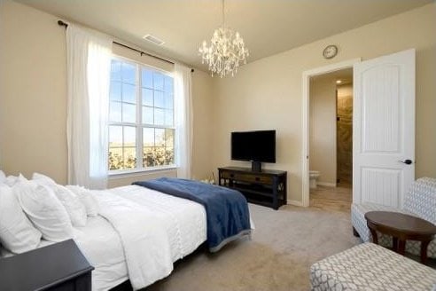 bedroom with carpet and a notable chandelier