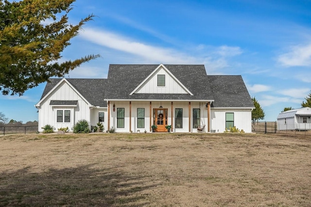 modern farmhouse style home with a front yard and covered porch