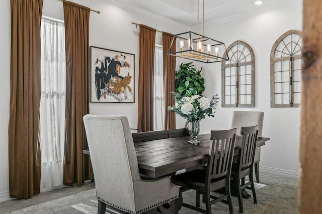 dining area featuring ornamental molding, carpet, and a notable chandelier