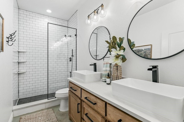 bathroom with toilet, tile patterned floors, tiled shower, and vanity