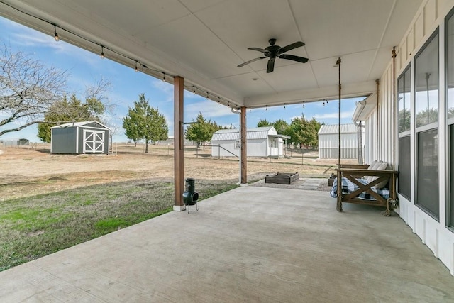 view of patio with ceiling fan and a storage shed