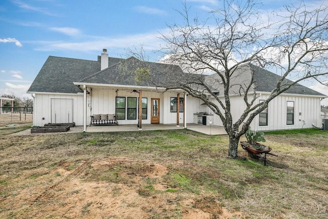 rear view of house with a patio area, ceiling fan, and a yard