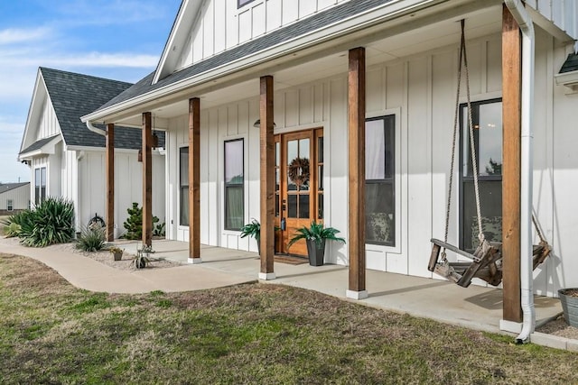 view of exterior entry featuring a porch and a lawn