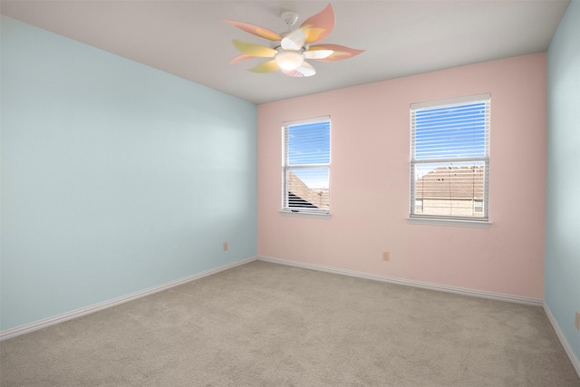 empty room with light colored carpet, plenty of natural light, and ceiling fan