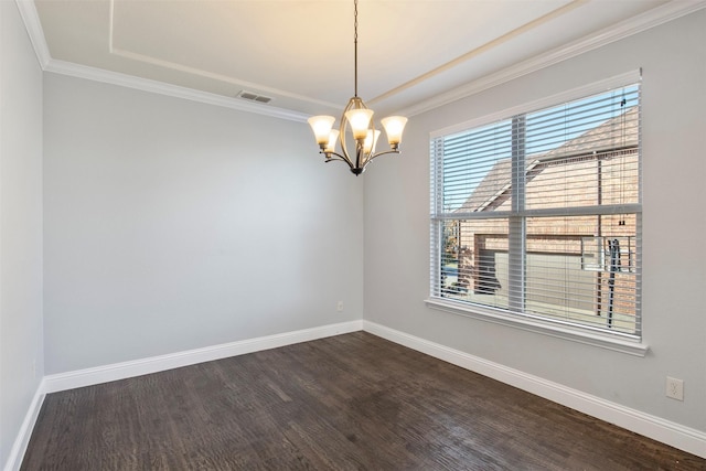 spare room featuring dark hardwood / wood-style floors, crown molding, and a chandelier