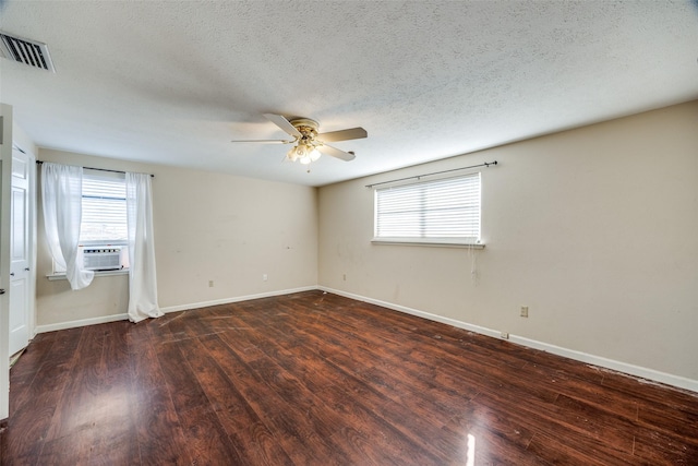 empty room featuring ceiling fan, dark hardwood / wood-style flooring, cooling unit, and a textured ceiling