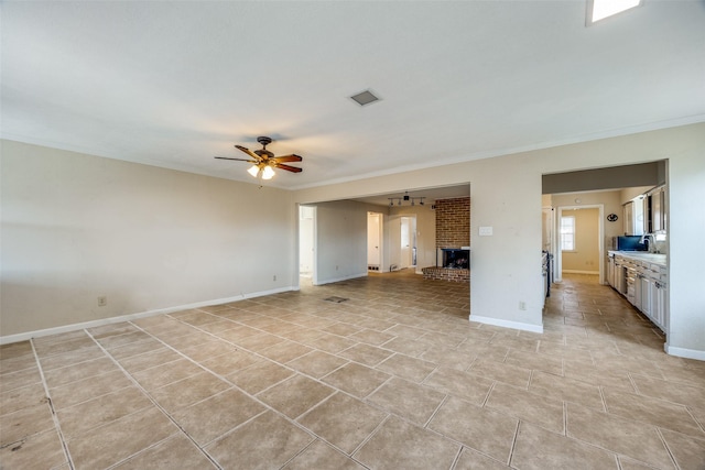 unfurnished living room with ceiling fan, ornamental molding, and a fireplace