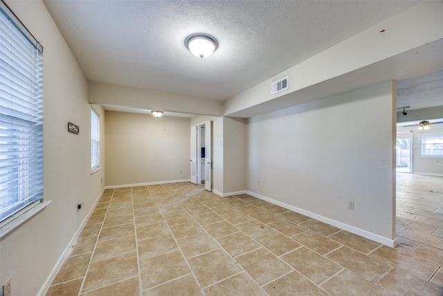 basement with a textured ceiling and ceiling fan