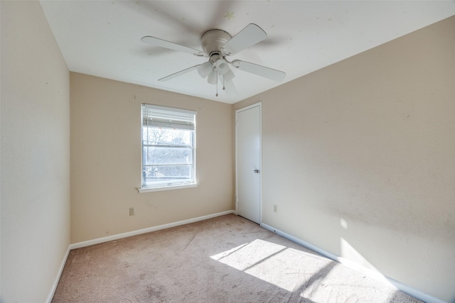 empty room with ceiling fan and light carpet