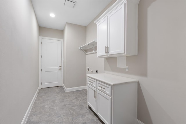 washroom featuring electric dryer hookup, baseboards, washer hookup, visible vents, and cabinet space