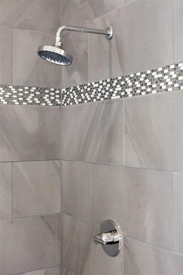 interior details featuring a tile shower
