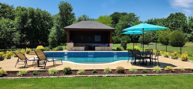 view of swimming pool featuring a fenced in pool, a patio area, an outbuilding, fence, and a lawn