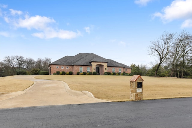 french country home with a front yard and brick siding