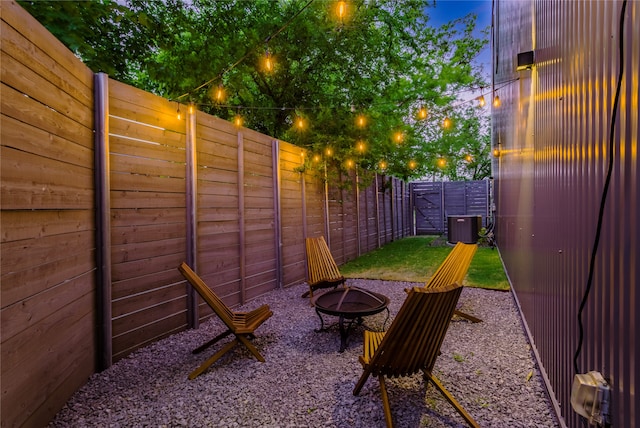 patio terrace at dusk featuring a fire pit and central AC