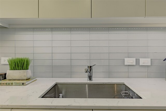 kitchen featuring light stone countertops and sink