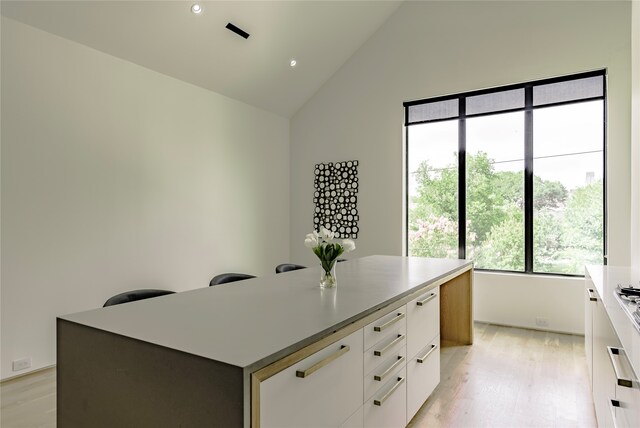 office with light hardwood / wood-style floors and vaulted ceiling