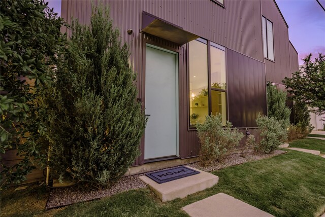 exterior entry at dusk with a lawn