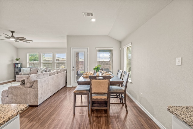 dining area with ceiling fan, dark wood-type flooring, and vaulted ceiling