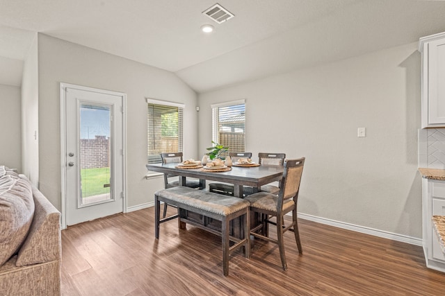 dining space with plenty of natural light, hardwood / wood-style floors, and vaulted ceiling