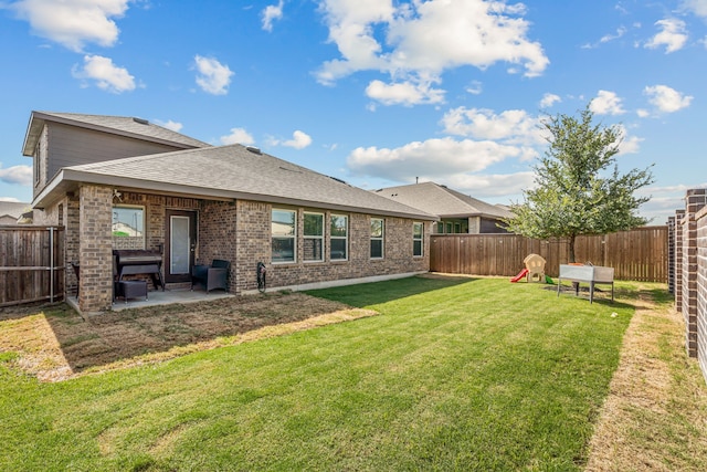 rear view of property featuring a yard and a patio area