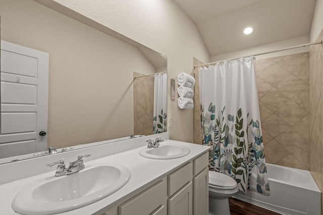 full bathroom featuring wood-type flooring, shower / bath combination with curtain, vaulted ceiling, toilet, and vanity