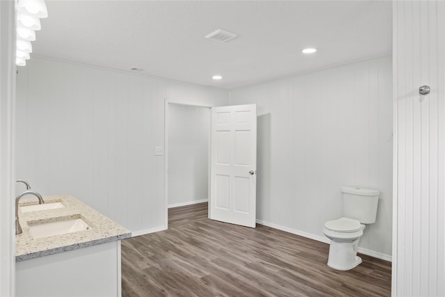 bathroom with vanity, wood walls, toilet, and wood-type flooring