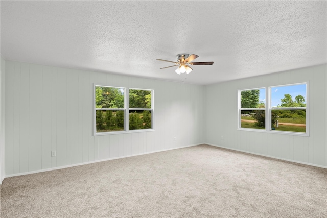 carpeted spare room featuring ceiling fan and a healthy amount of sunlight