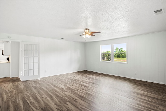 unfurnished room with a textured ceiling, ceiling fan, and dark wood-type flooring