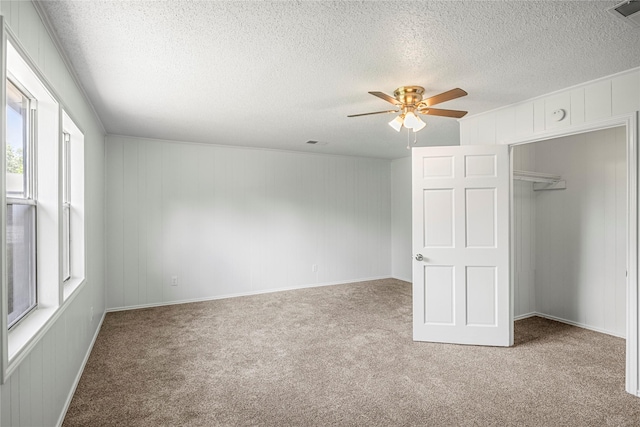 unfurnished bedroom with multiple windows, carpet flooring, a closet, and ceiling fan