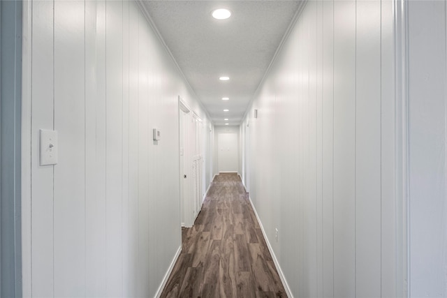 corridor with a textured ceiling, dark hardwood / wood-style flooring, and crown molding