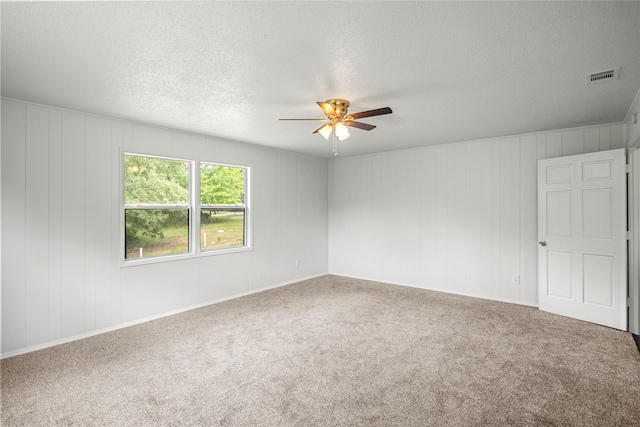 unfurnished room featuring a textured ceiling, carpet floors, and ceiling fan