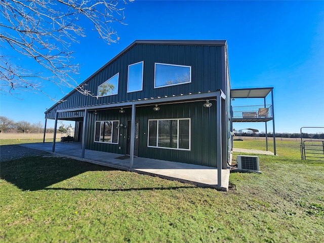 back of property featuring central AC, a patio area, and a lawn